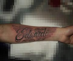Tatuaje de fondo de alas con nombre Eduardo