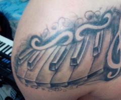 Tatuaje teclas de piano y clave de sol