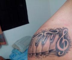 Tatuaje teclas de piano y clave de sol