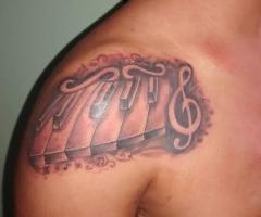 Tatuaje teclas de piano y clave de sol