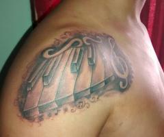 Tatuaje teclas de piano y clave de sol