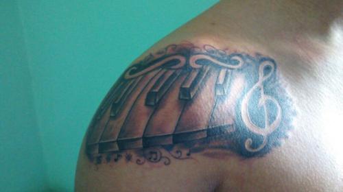 Tatuaje teclas de piano y clave de sol