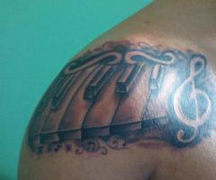 Tatuaje teclas de piano y clave de sol