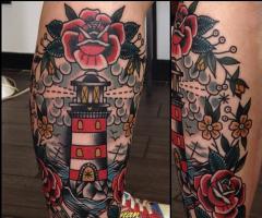 Lighthouse framed with roses tattoo