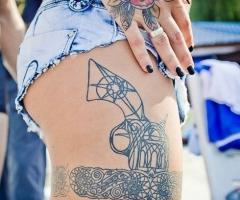 The gun tucked into the garter tattoo