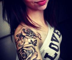 Hermoso brazo y hombro femenino tatuado con rosas