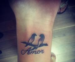 Tatuaje de dos palomas y la palabra amor