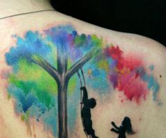 Tatujae de dos niños jugando en un árbol