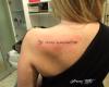 Tatuaje de frase en la espalda